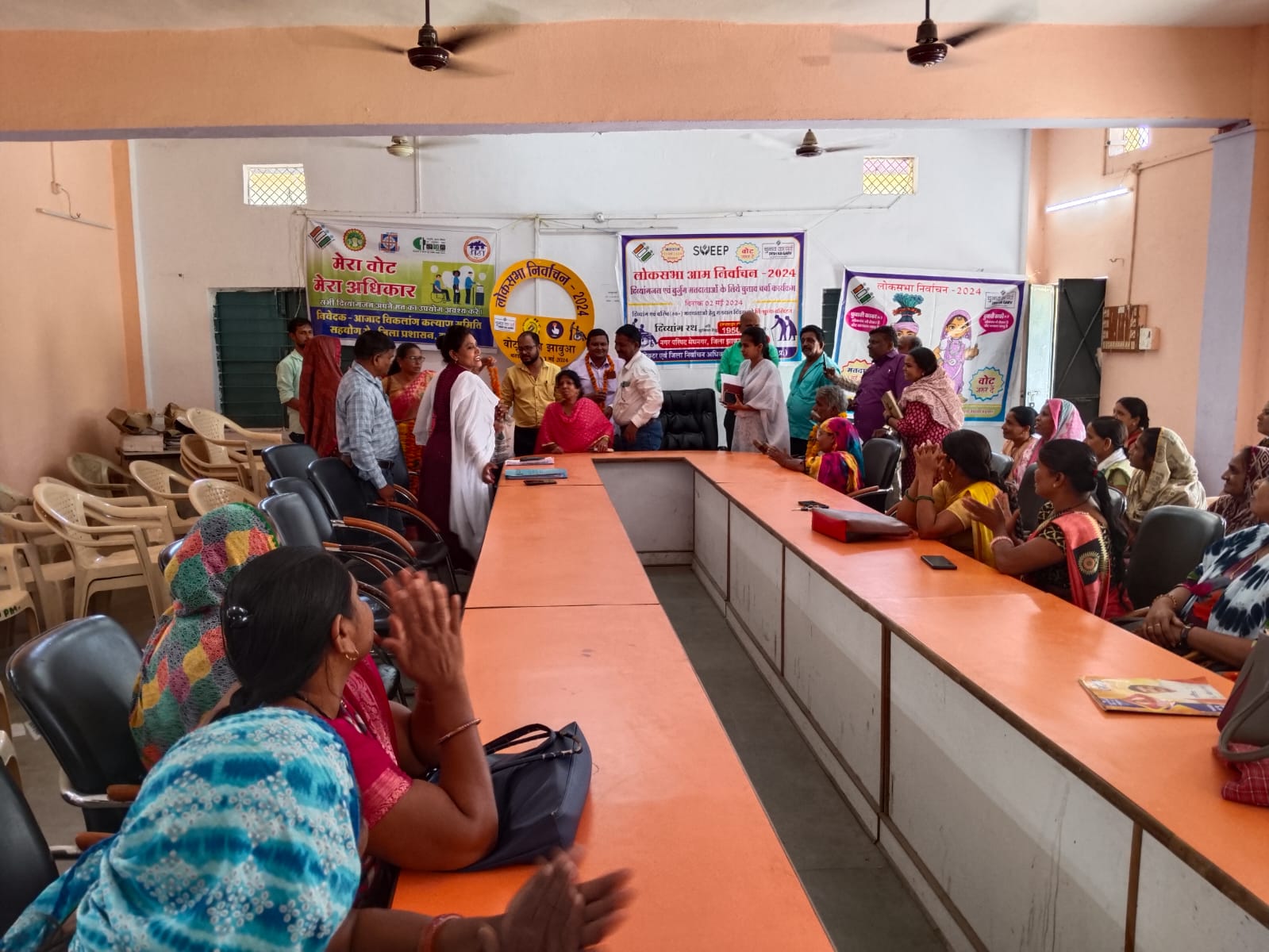 Meghnagar Anganwadi workers are knocking door to door and giving invitations by giving yellow rice.